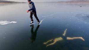 Mężczyzna nurkuje pod lodem, po którym jego kolega jeździ na łyżwach. Coś napraw
